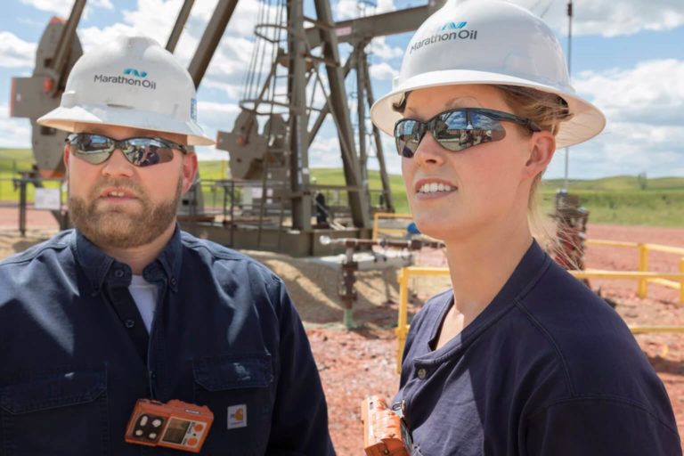 Marathon employees in front of oil rig