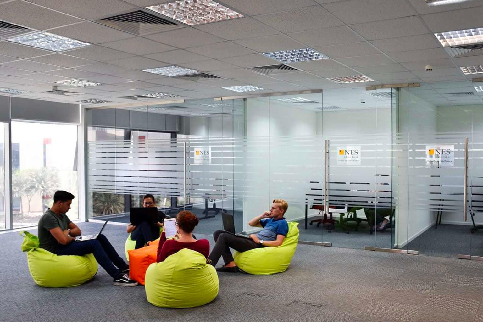 Employees work on beanbag chairs in office