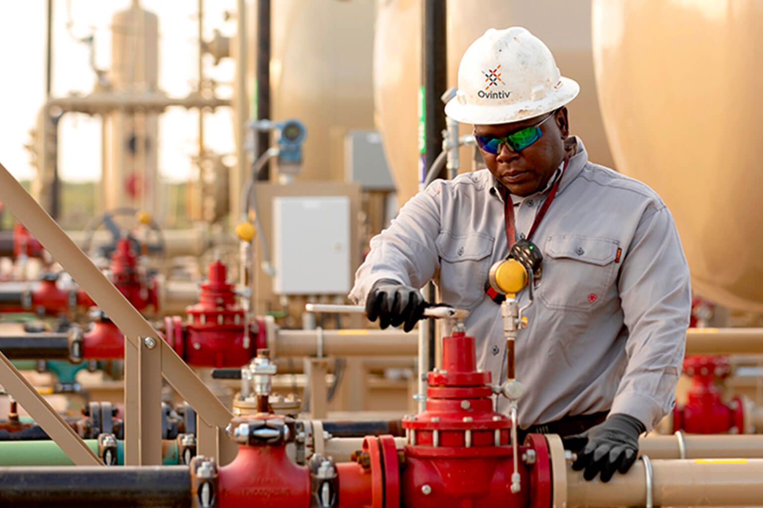 Person wearing safety gear tightening a valve