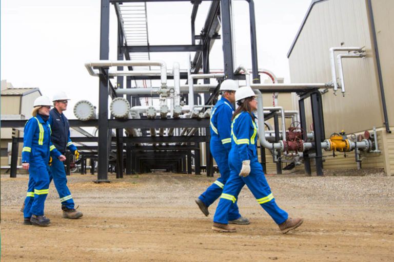 People wearing safety gear walking at worksite