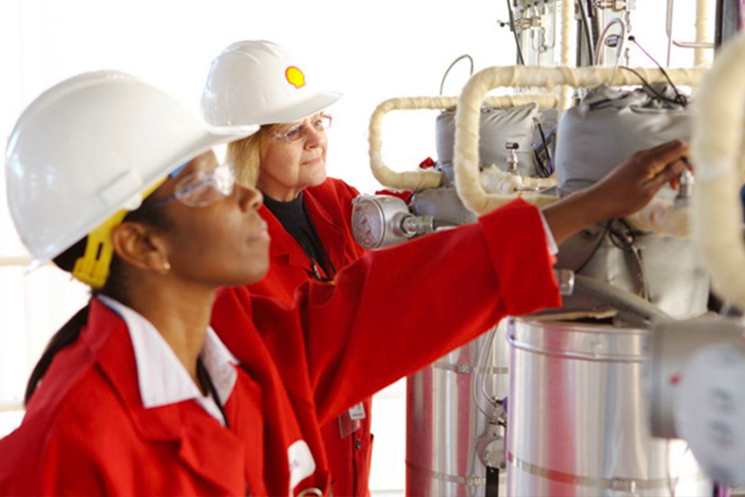 People wearing safety gear checking equipment