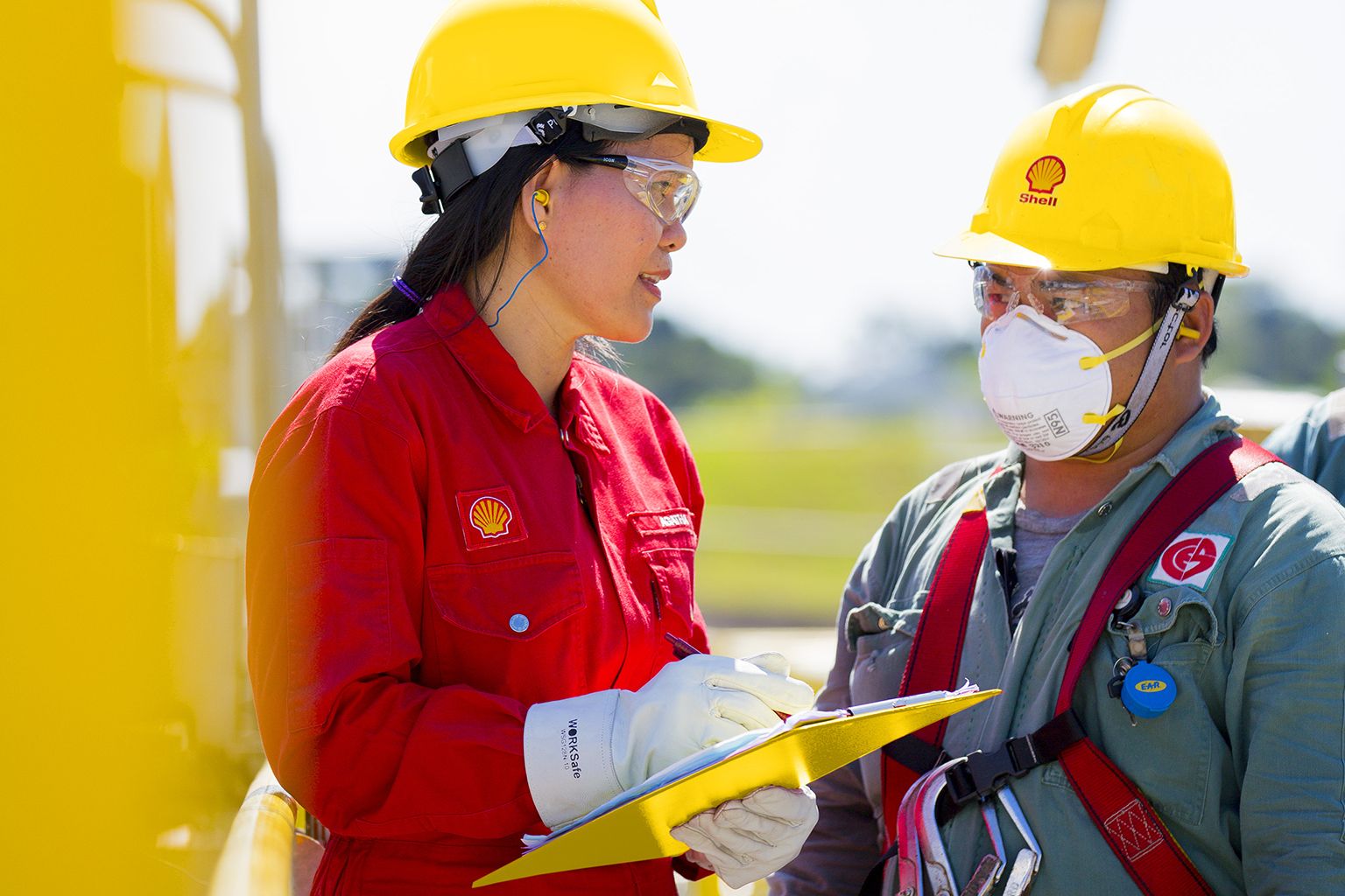 Two people talking wearing hard hats and safety gear