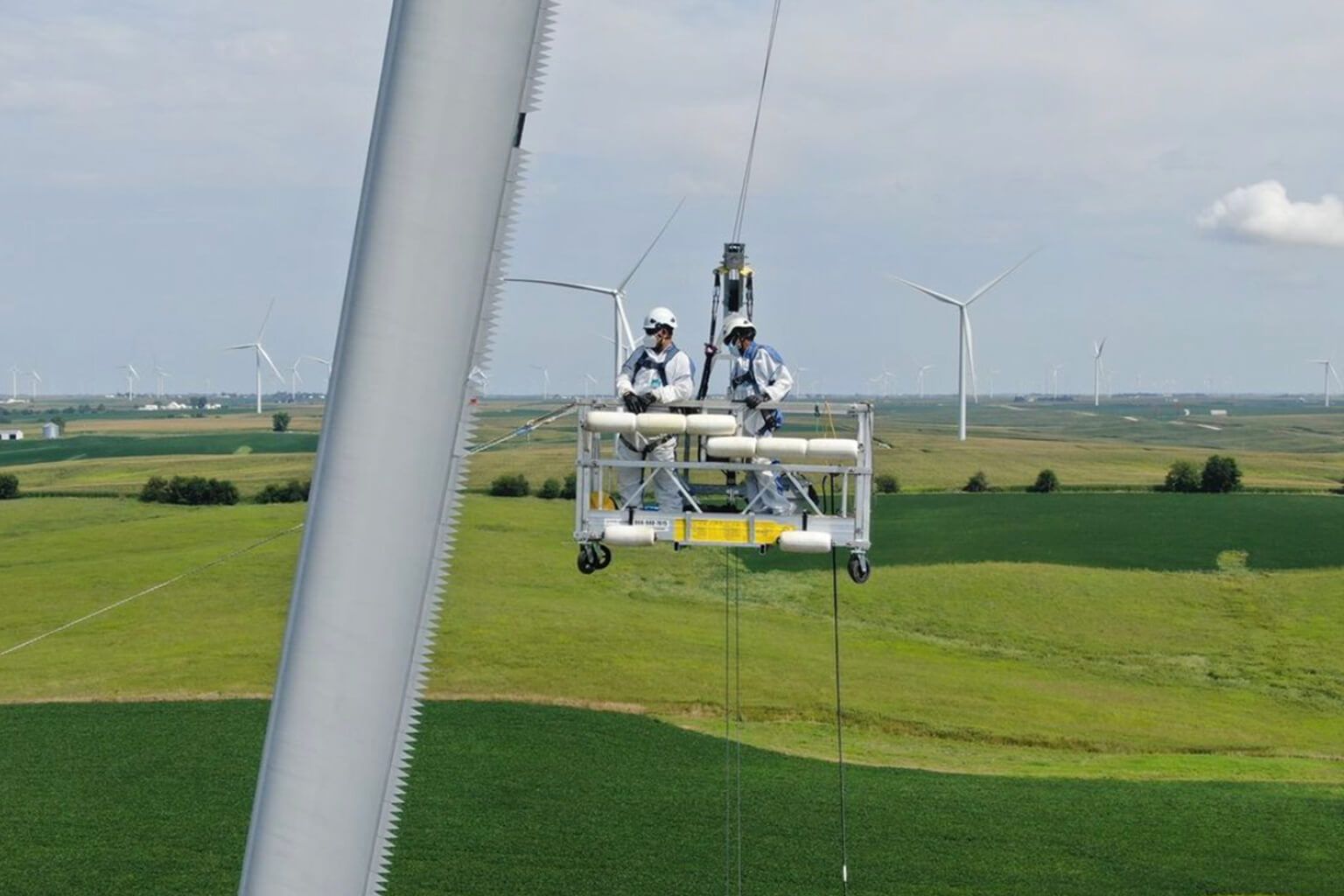 Two people repairing wind turbine